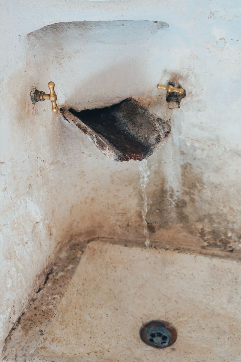 Brown water stain spreading across a plaster ceiling